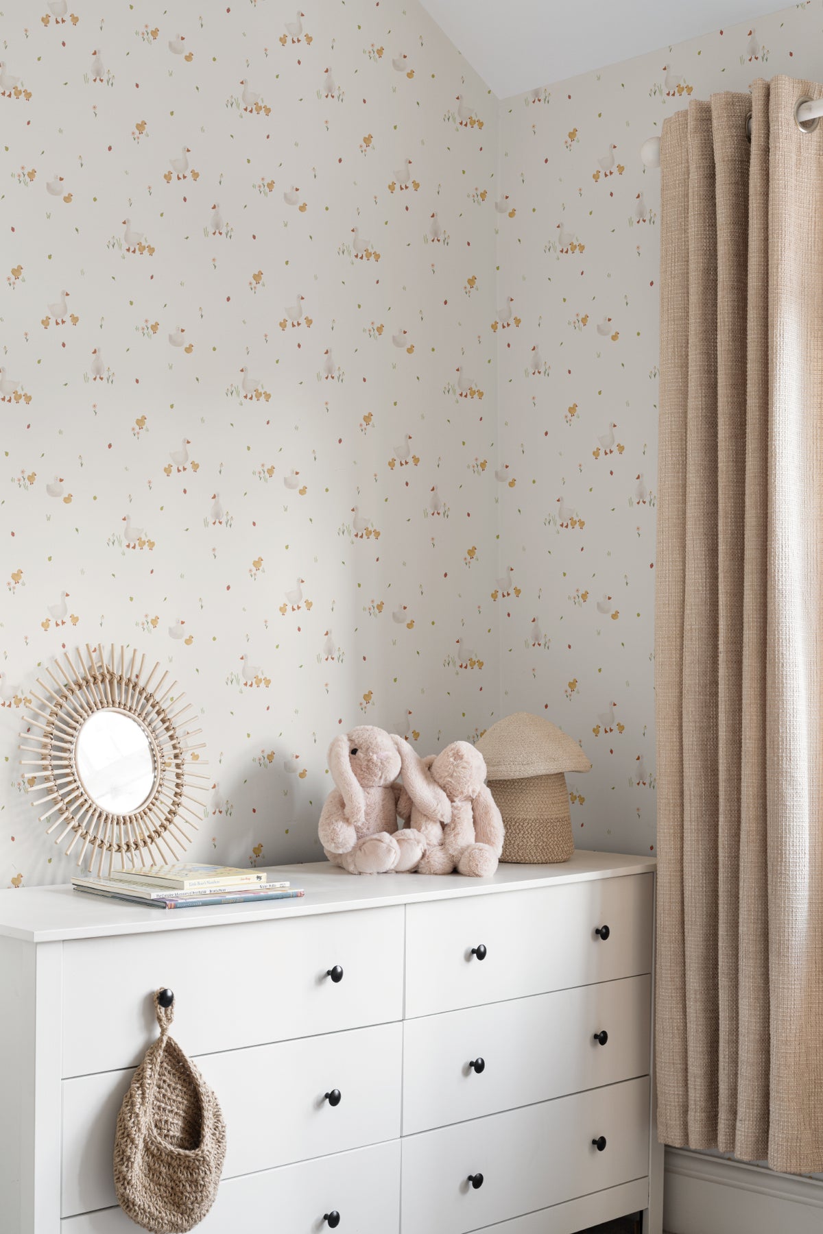 The Mallard Meadow wallpaper in buttermilk and beige behind a styled console