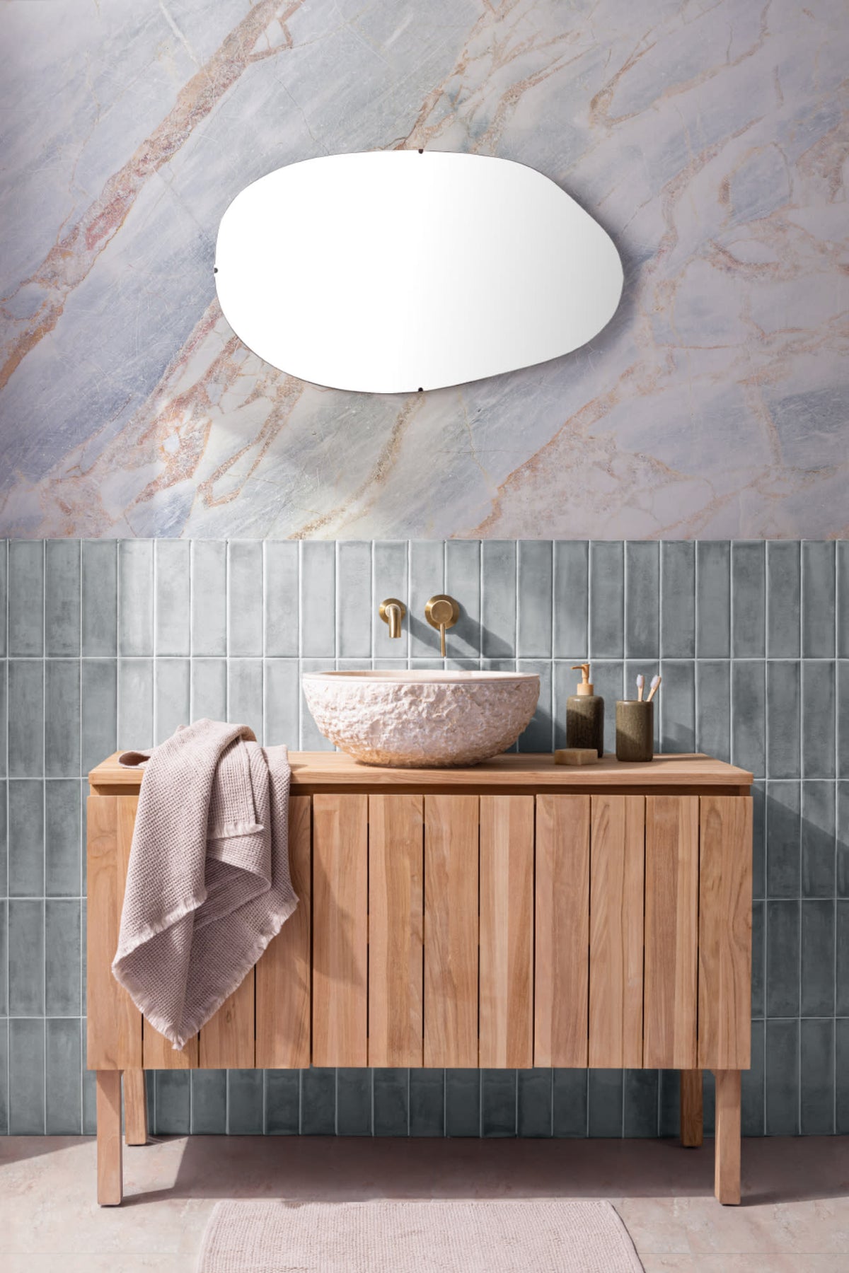The Marble Fissure mural in pale stone and bronze behind a bathroom vanity