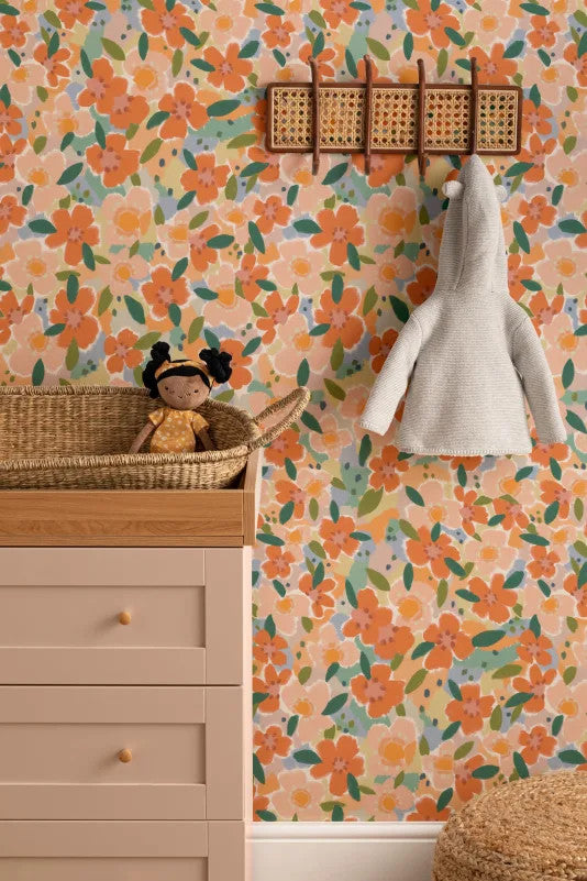 The Marmalade Bloom wallpaper in tangerine and blush on a nursery wall