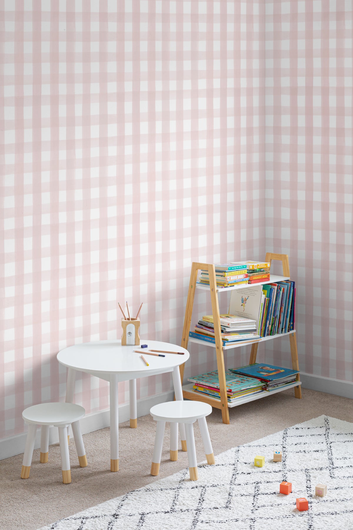 The Meadow Gingham wallpaper in ballet pink in a children's room setting