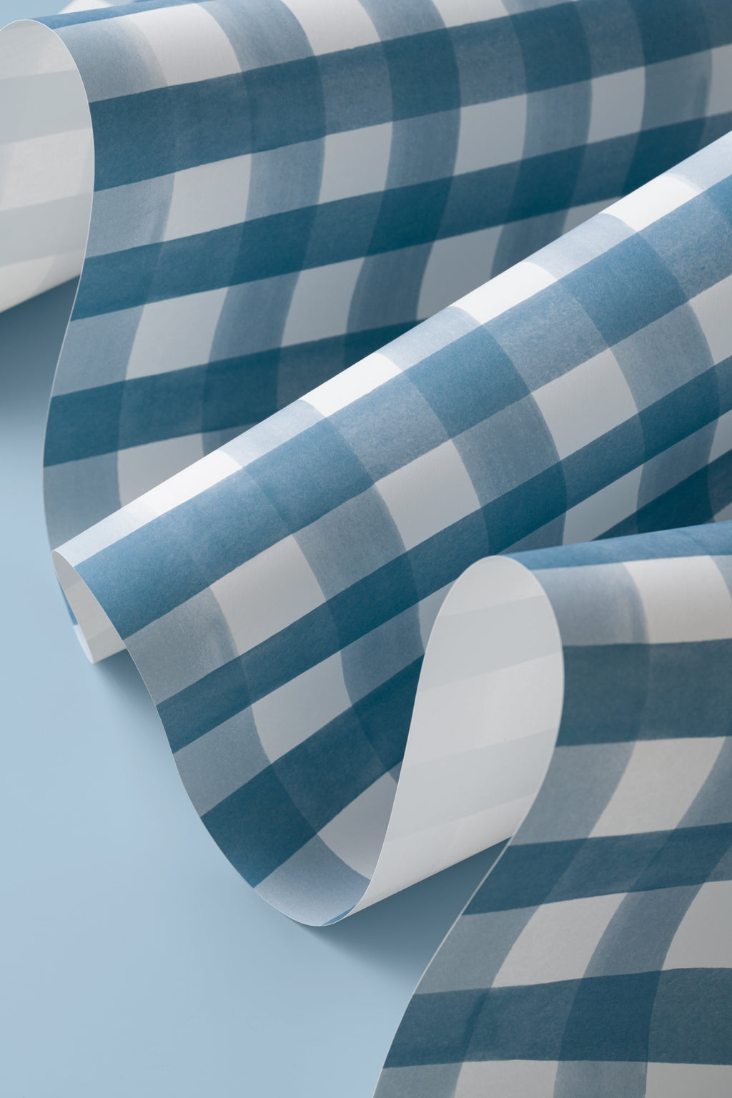 Angled detail of The Meadow Gingham wallpaper in navy and chambray