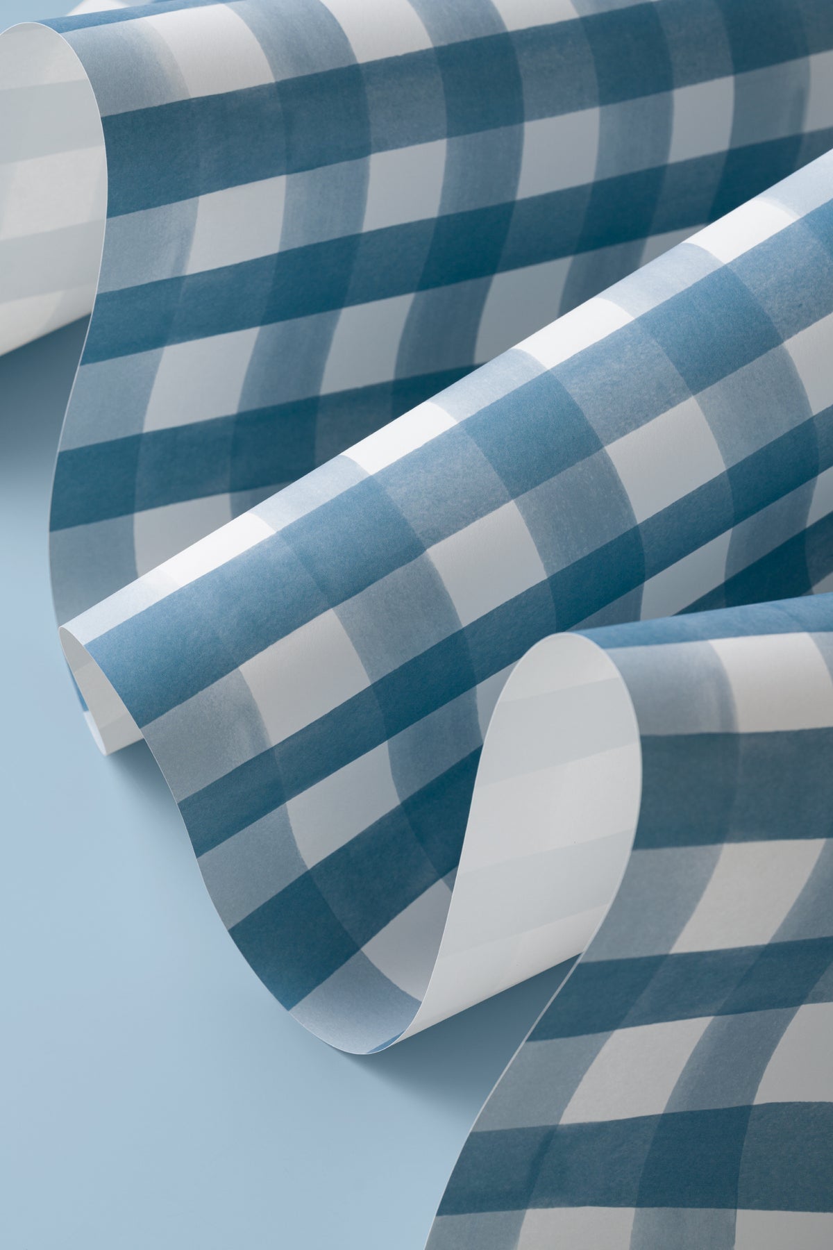Angled detail of The Meadow Gingham wallpaper in navy and chambray