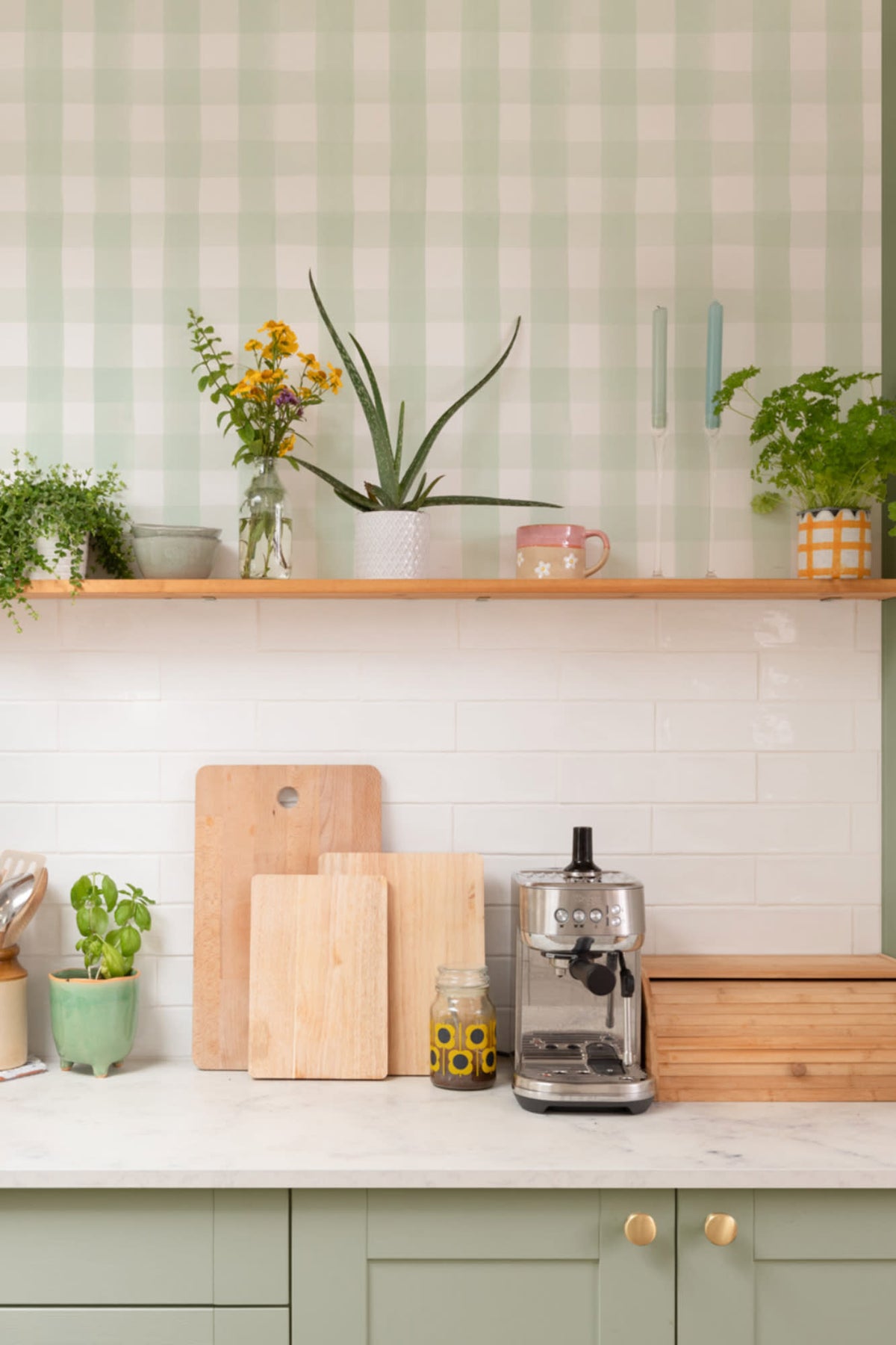 The Meadow Gingham wallpaper in sage green and white behind a styled console