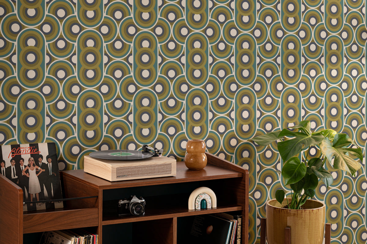 The Mod Portico wallpaper in olive and chocolate in a study corner with a desk