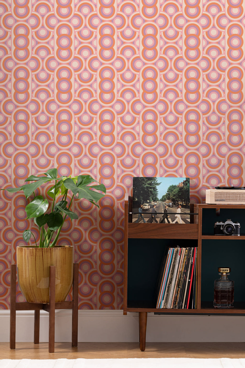 The Mod Portico wallpaper in tangerine and pink behind a styled console