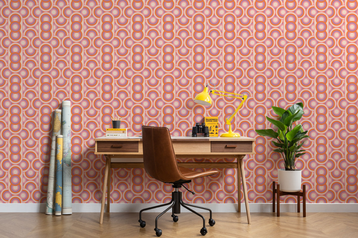 The Mod Portico wallpaper in tangerine and pink behind a desk in a home office