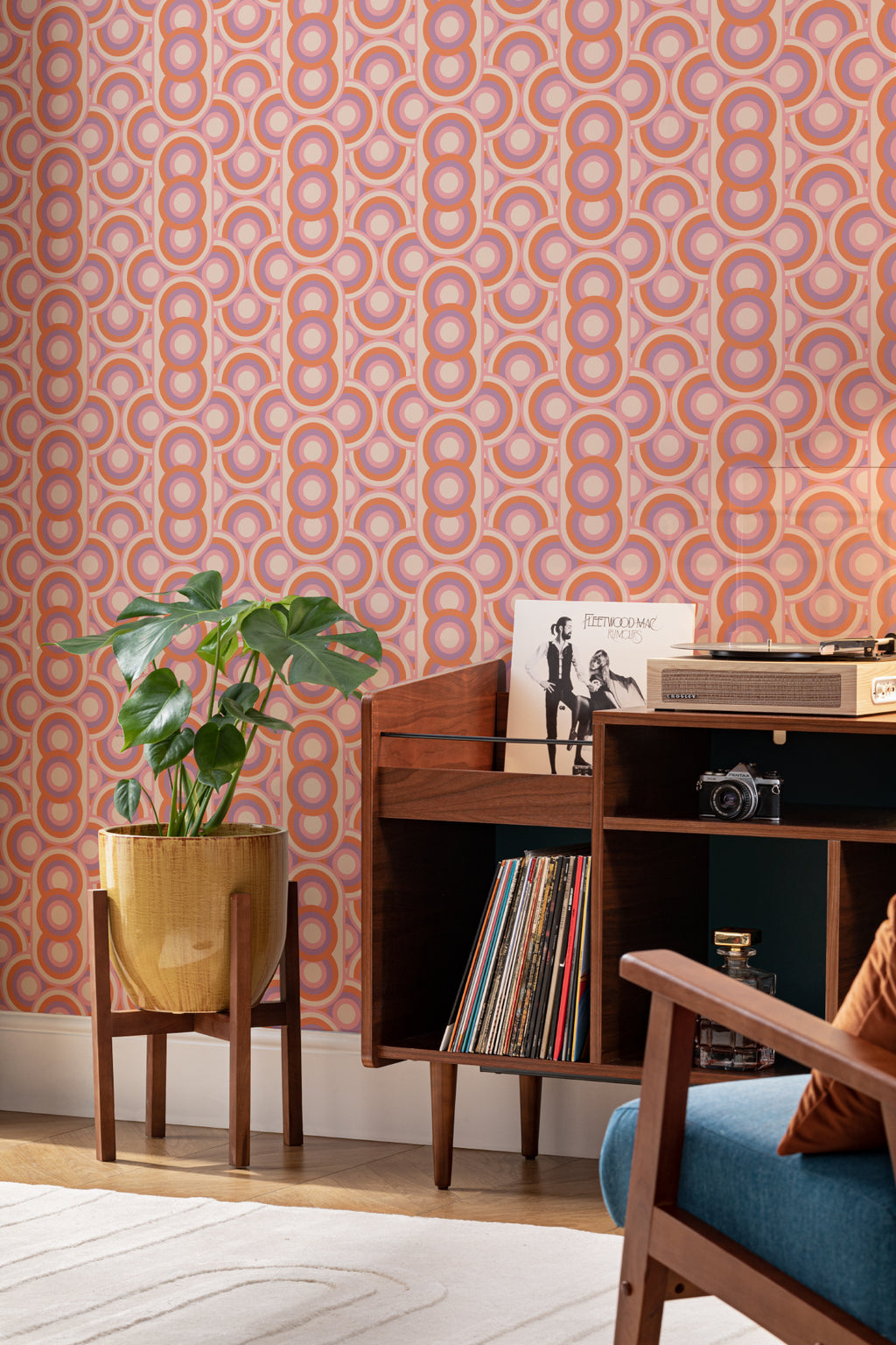 The Mod Portico wallpaper in tangerine and pink in a styled vignette