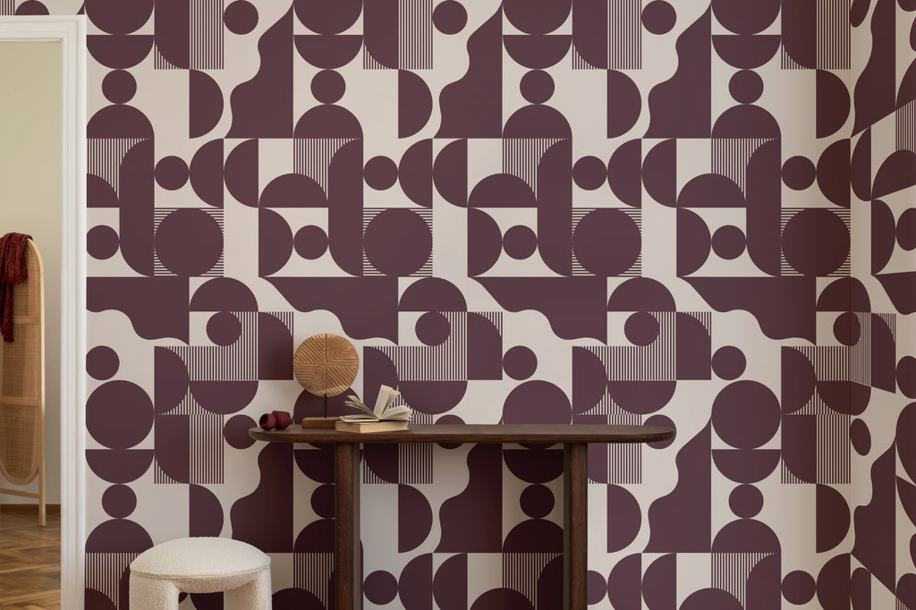 The Modernist Quadrant wallpaper in burgundy plum behind a styled console