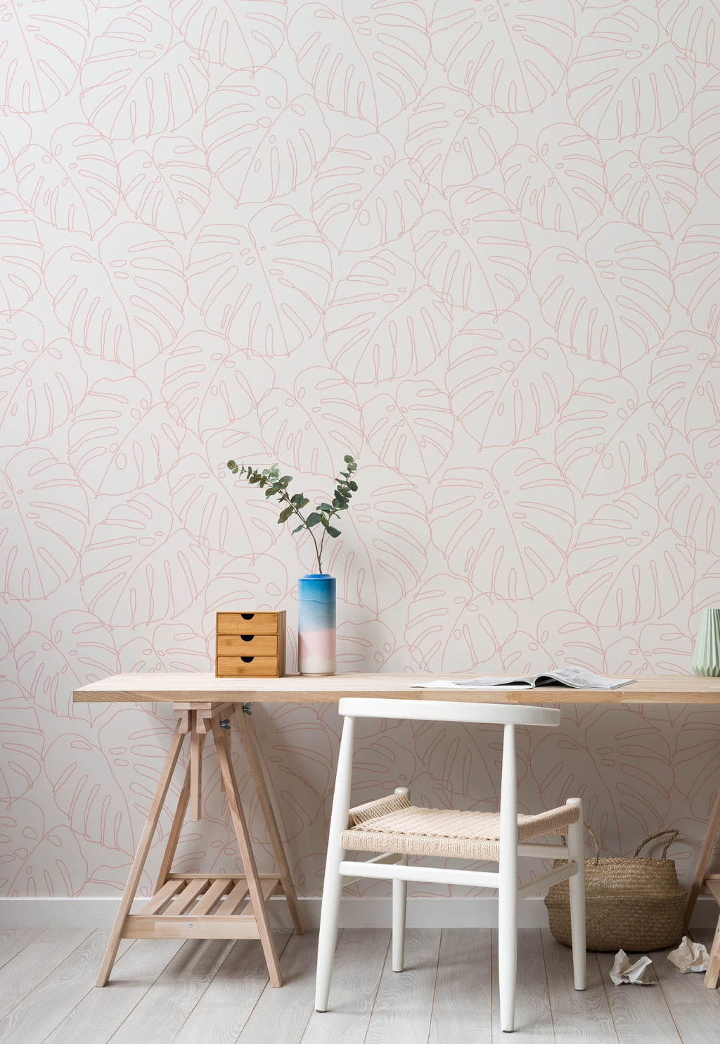 The Monstera Loggia wallpaper in blush and cream behind a desk in a home office