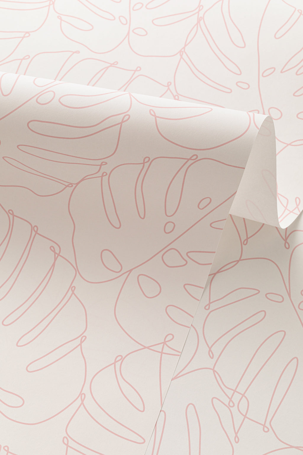 Angled detail of The Monstera Loggia wallpaper in blush and cream