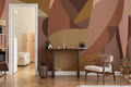 The Muse Silhouette mural in cinnamon and rose behind a desk in a home office