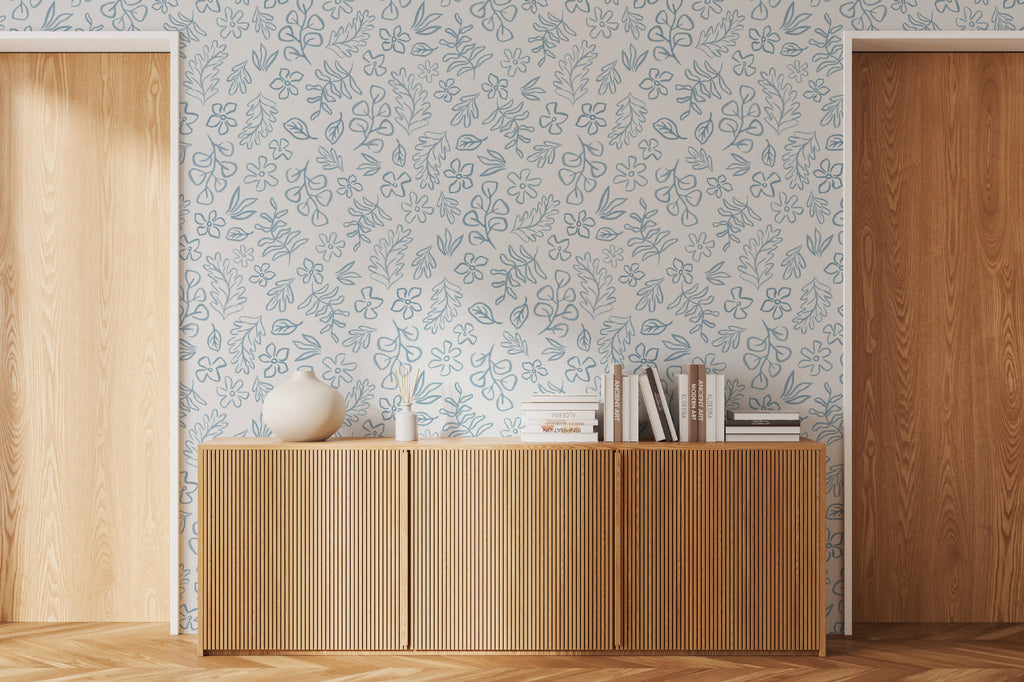 The Nordic Bough wallpaper in soft denim blue as a backdrop to styled furniture