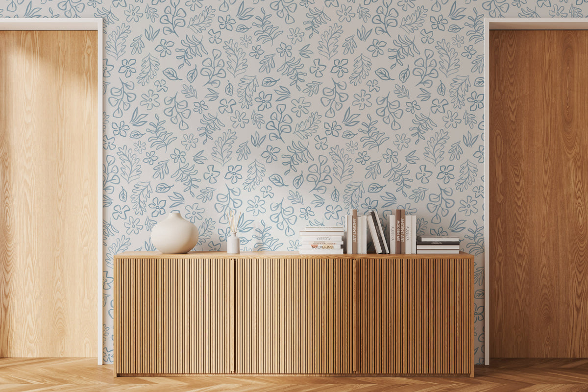 The Nordic Bough wallpaper in soft denim blue as a backdrop to styled furniture