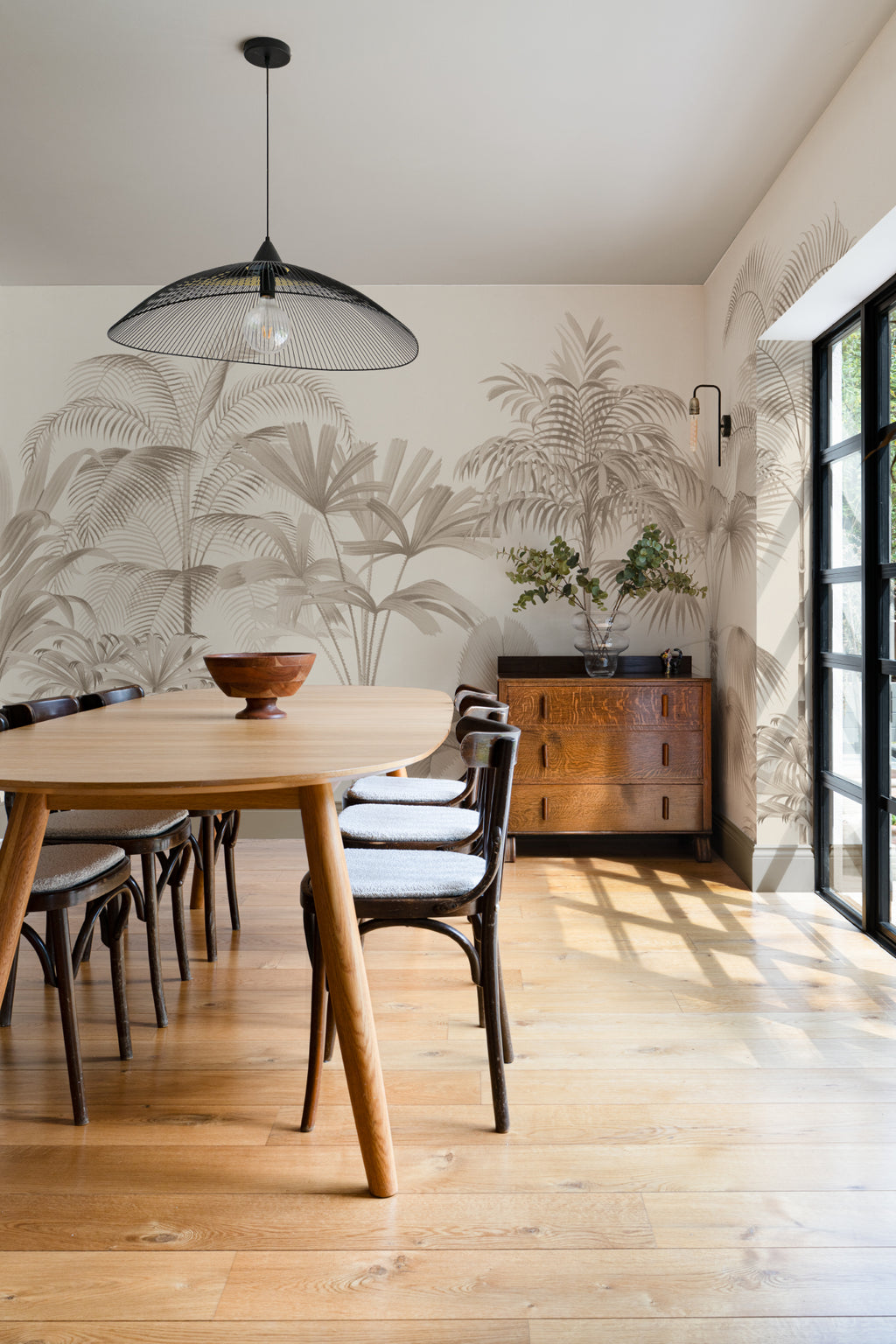 The Oasis Palms mural in sepia and sand behind a dining table