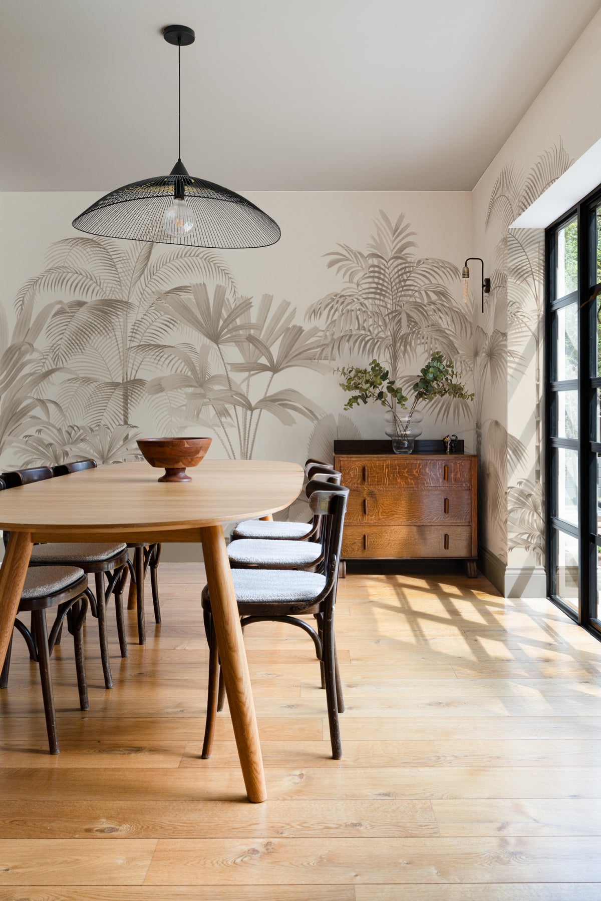 The Oasis Palms mural in sepia and sand behind a dining table