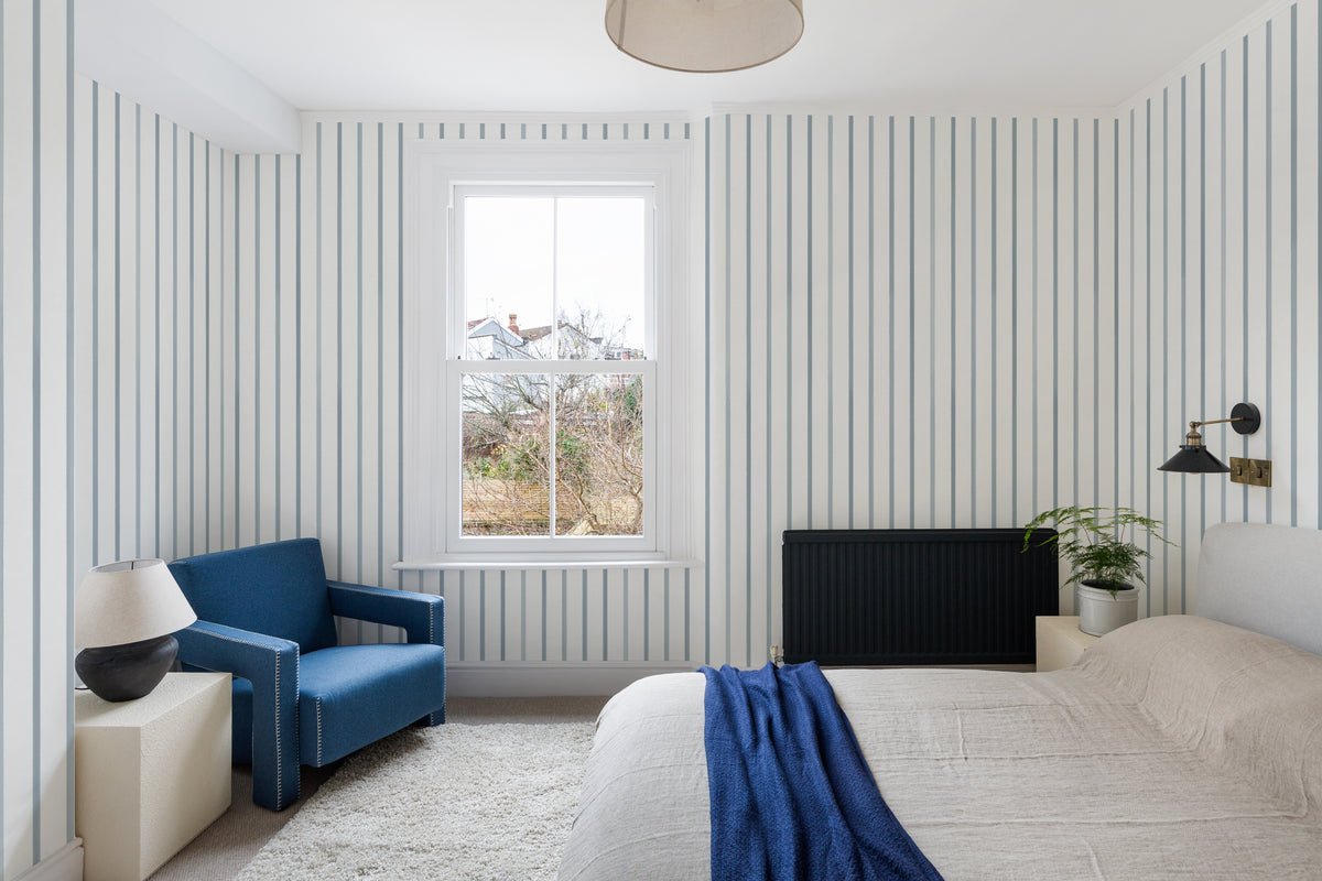 The Oxford Pinstripe mural in chambray blue on a nursery wall
