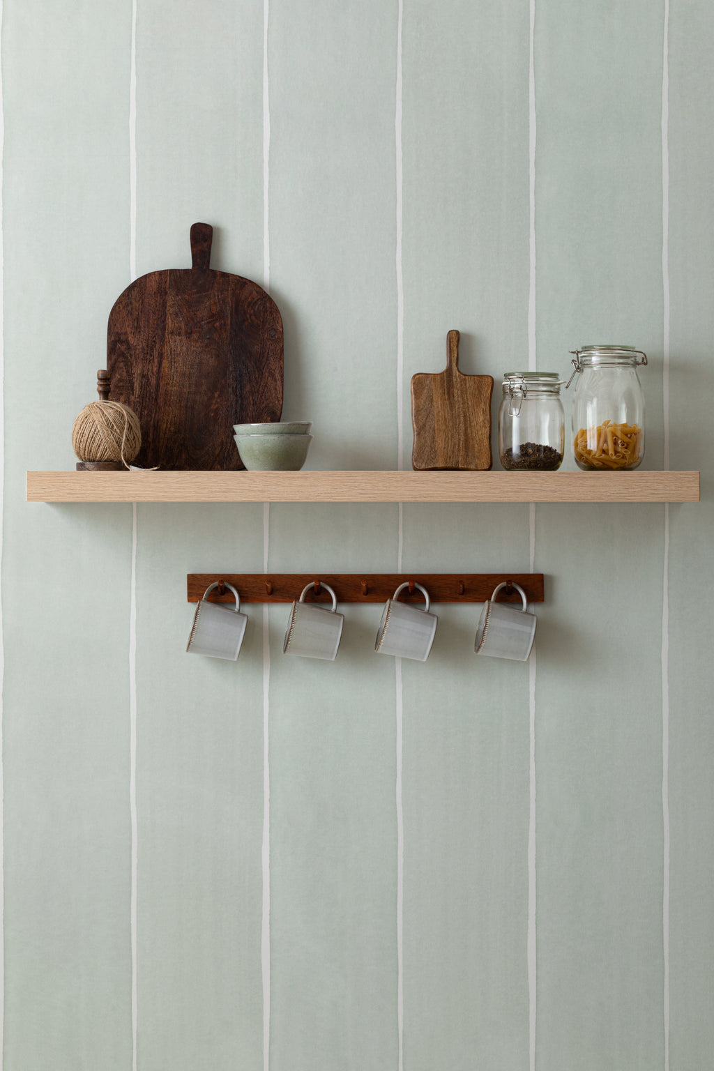 The Painted Awning wallpaper in mint sage as a backdrop to styled furniture