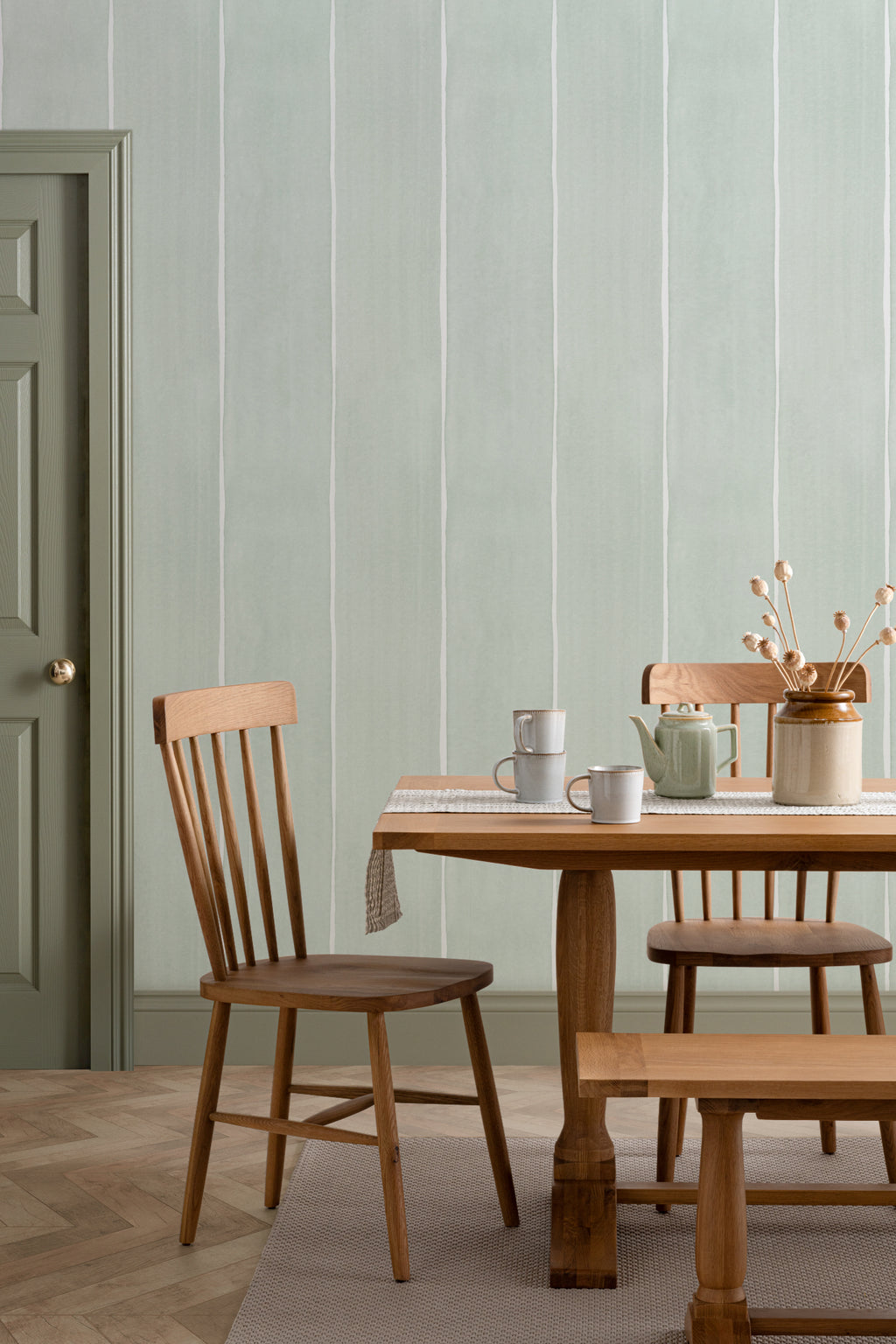 The Painted Awning wallpaper in mint sage behind a dining table