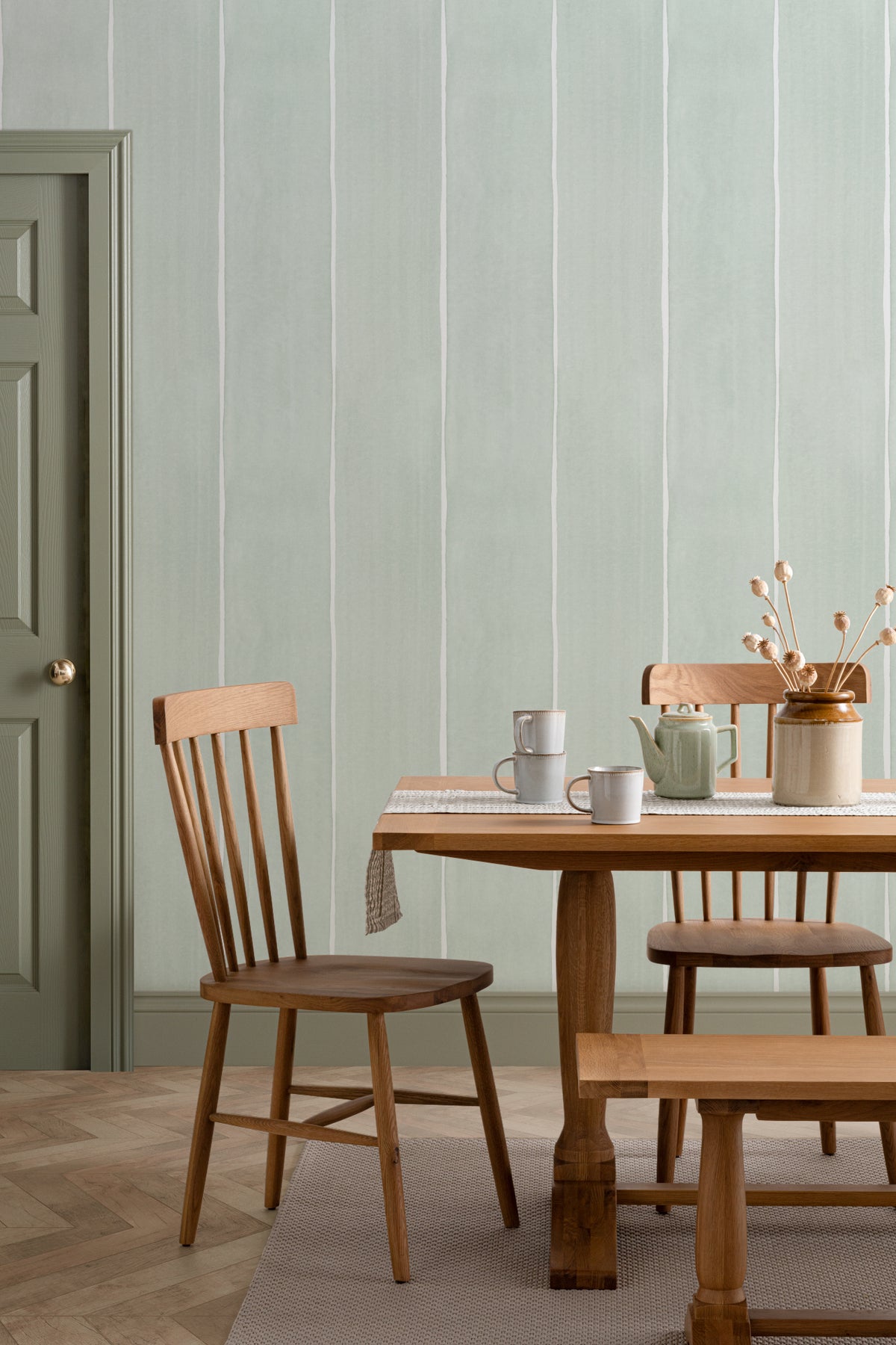 The Painted Awning wallpaper in mint sage behind a dining table