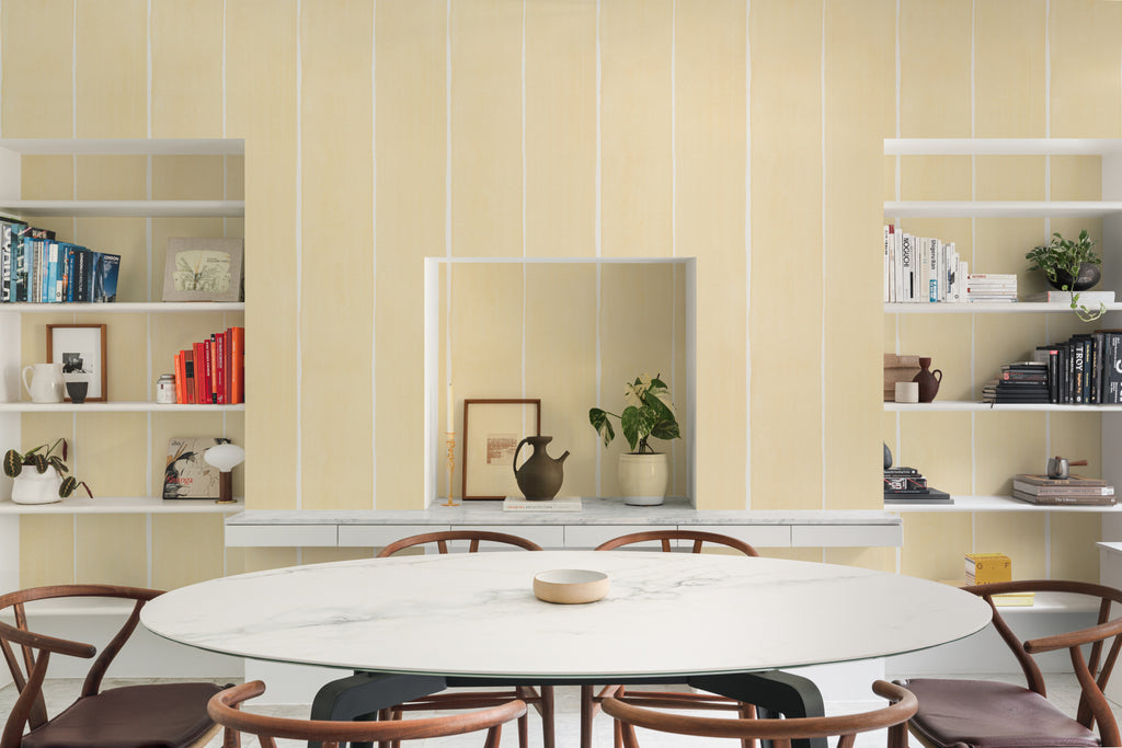 The Painted Awning wallpaper in pale primrose behind a dining table