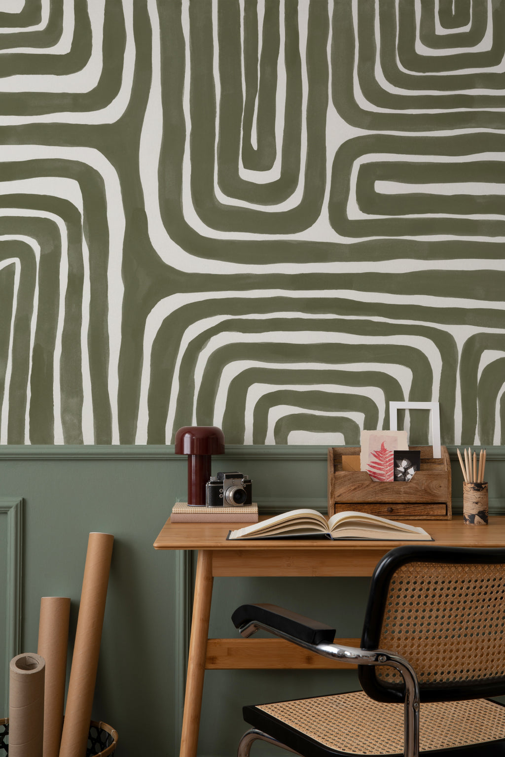 The Painted Labyrinth mural in olive and cream behind a dining table