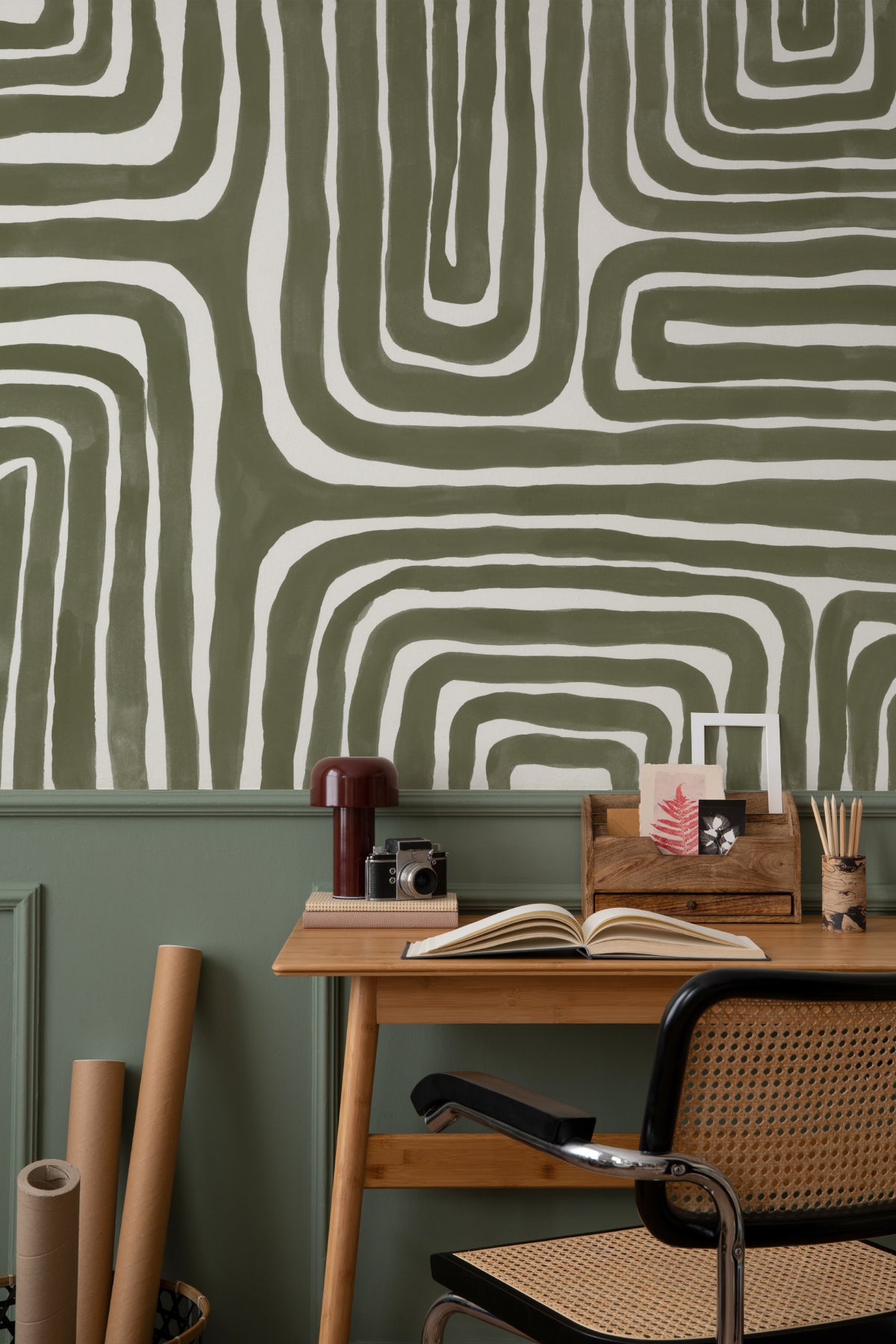The Painted Labyrinth mural in olive and cream behind a dining table
