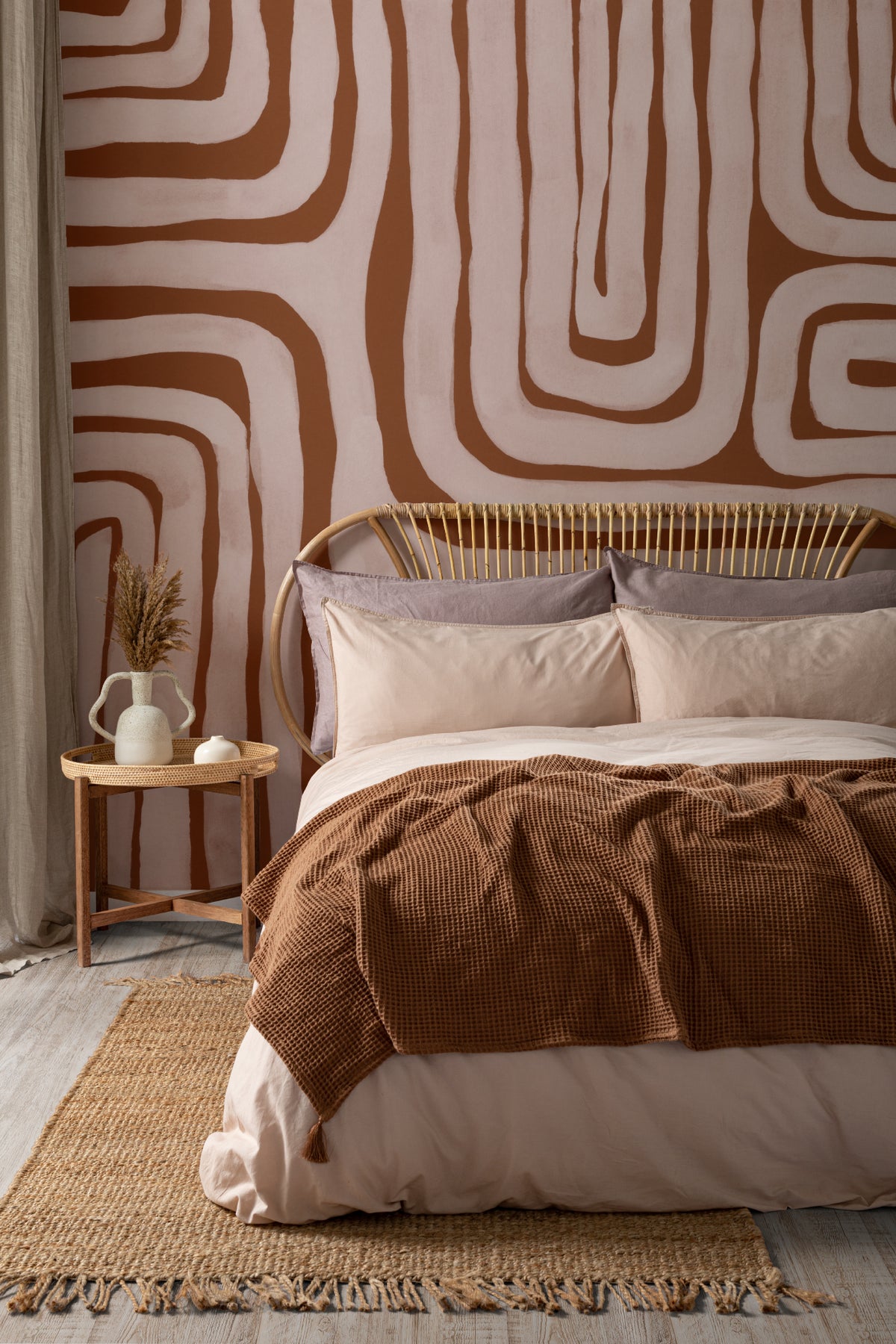 The Painted Labyrinth mural in terracotta and rose behind the bed in a bedroom