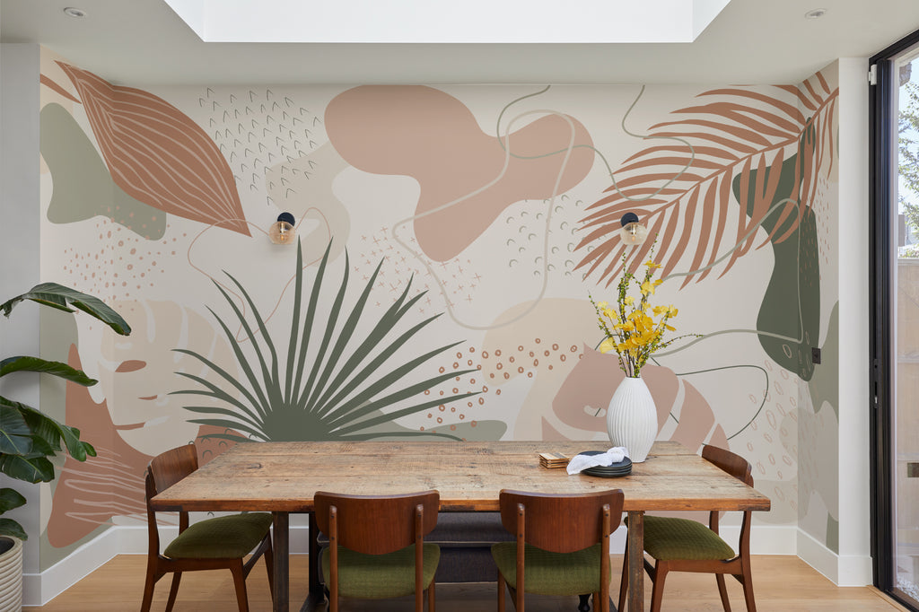 The Palm Cutout mural in clay pink and sage behind a dining table