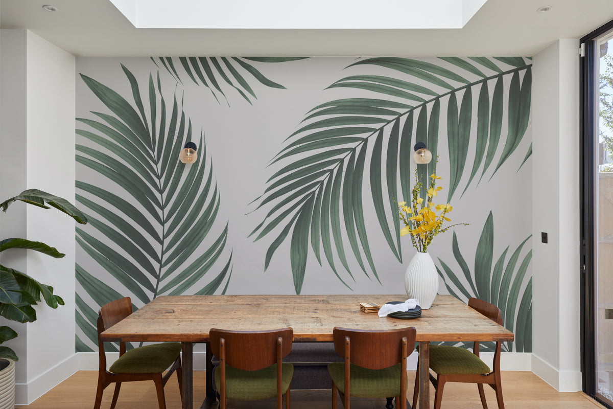 The Palm Shade mural in palm green and dove grey behind a dining table
