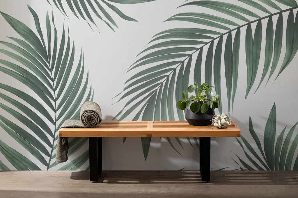The Palm Shade mural in palm green and dove grey as a backdrop to styled furniture