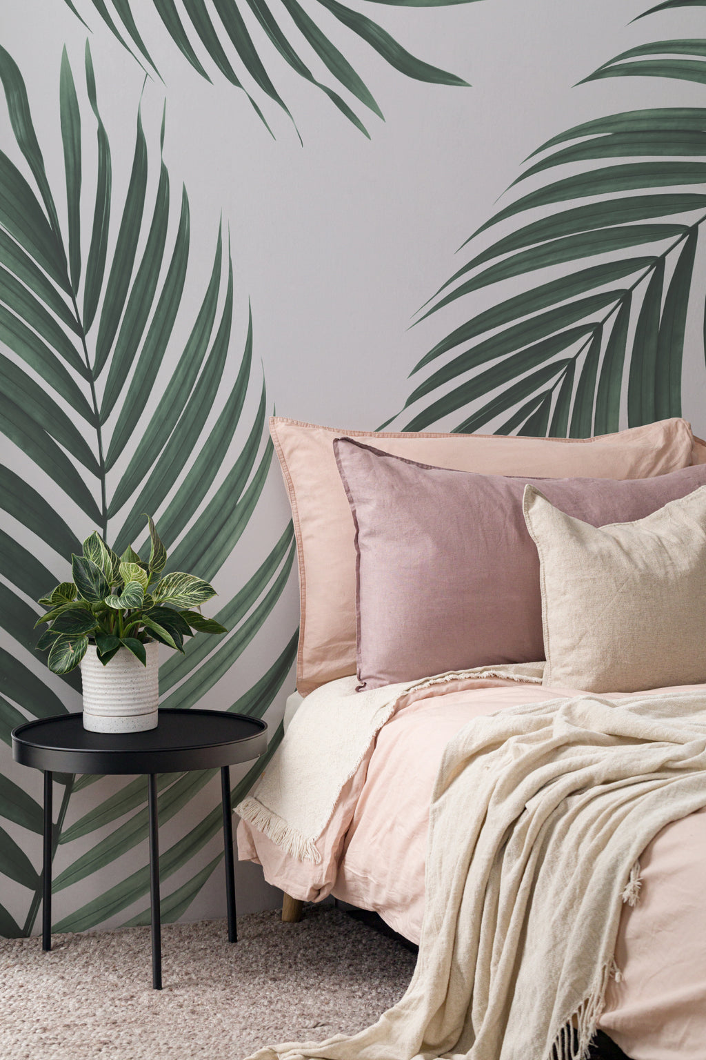 The Palm Shade mural in palm green and dove grey behind the bed in a bedroom