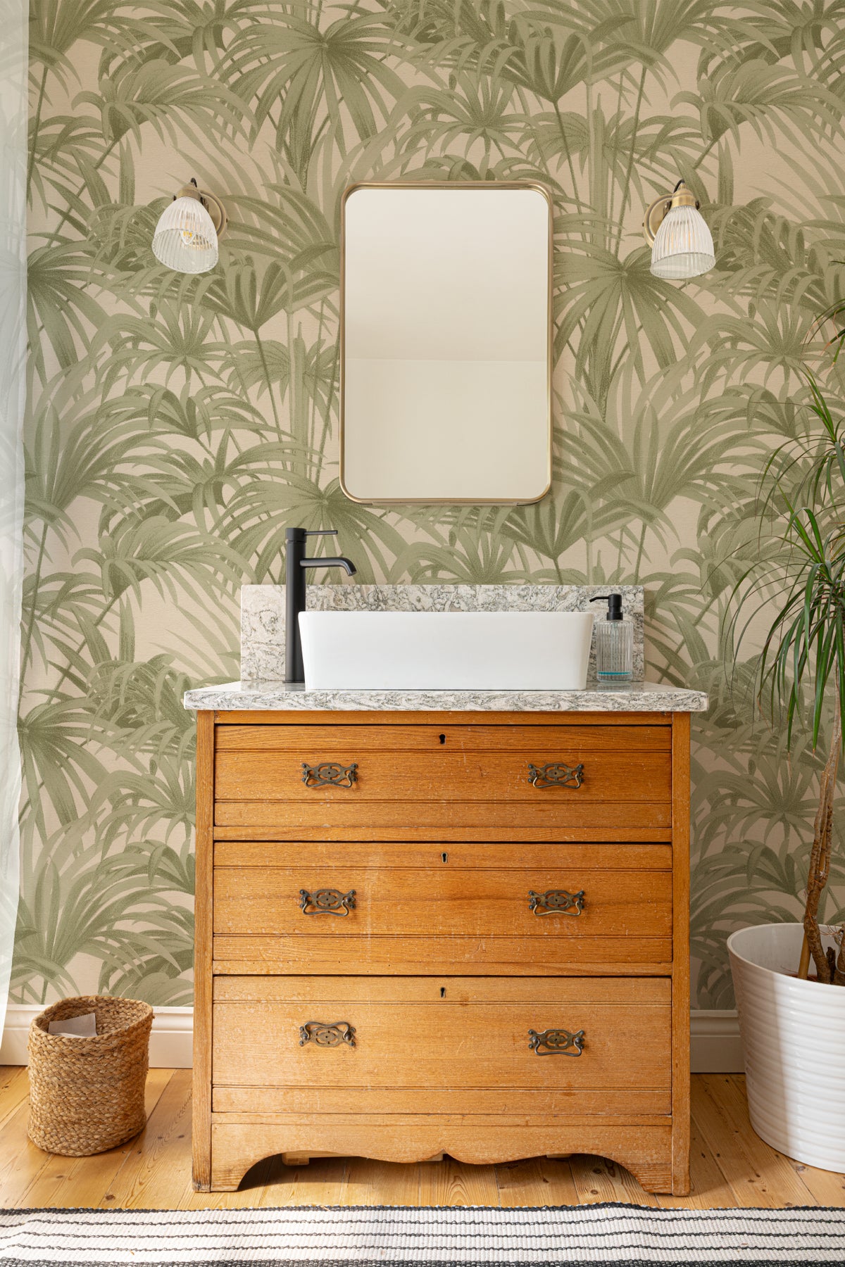 The Palmery Walk wallpaper in olive and sand behind a styled console