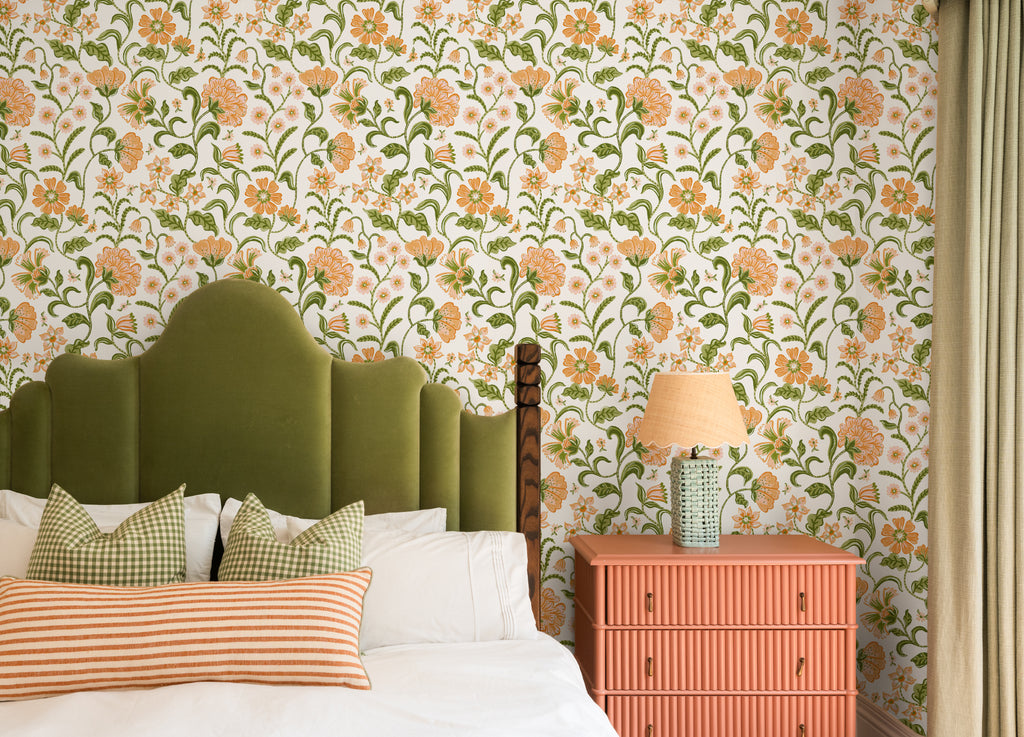 The Pavilion Garland wallpaper in marigold and leaf green behind the bed in a bedroom