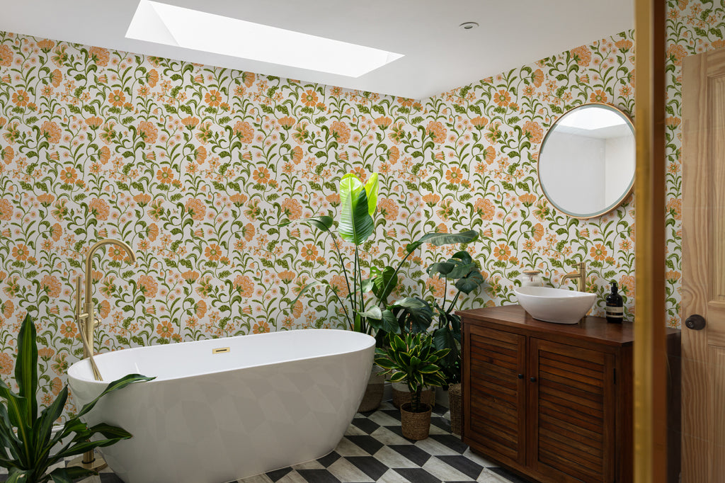 The Pavilion Garland wallpaper in marigold and leaf green in a styled room setting