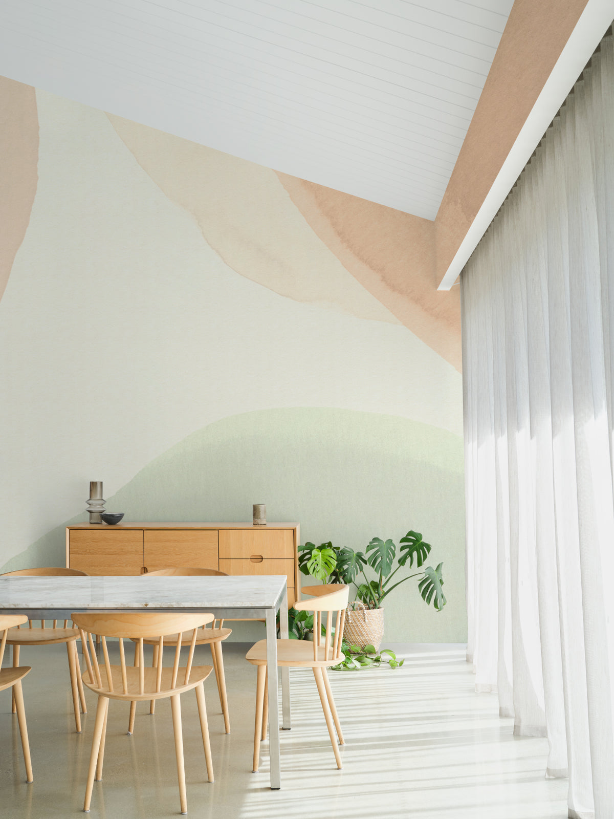 The Pebble Wash mural in peach and sage behind a styled console
