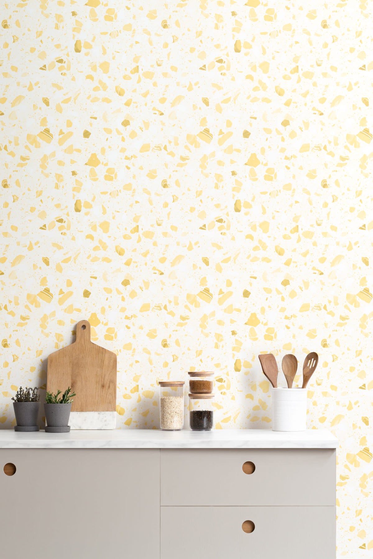 The Piazza Terrazzo wallpaper in lemon yellow behind a styled console