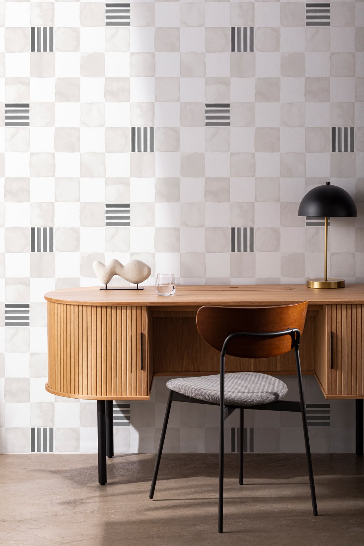 The Plaster Chequer wallpaper in soft greige behind a desk in a home office