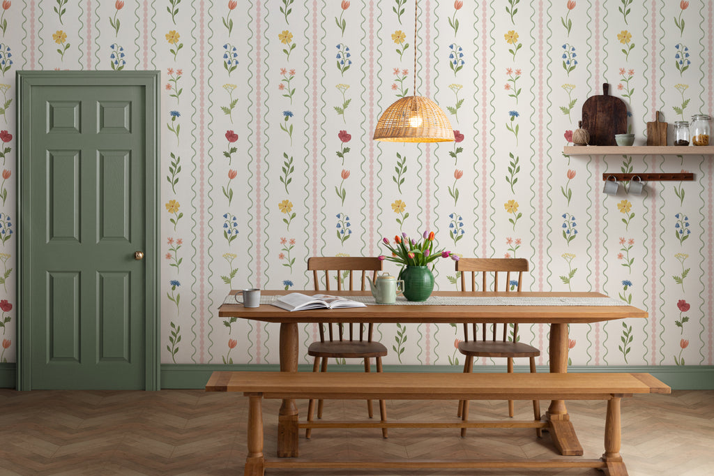 The Posy Braid mural in blush pink behind a dining table