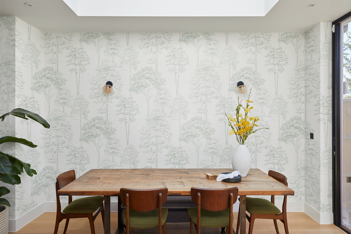 The Quiet Arboretum wallpaper in pale sage behind a dining table