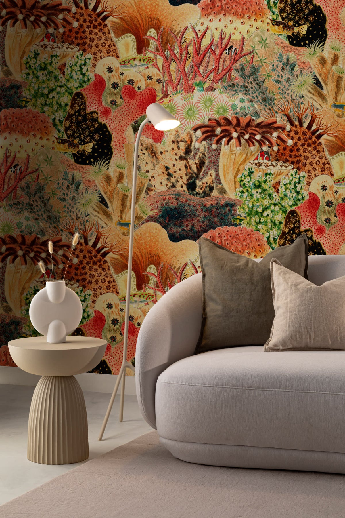 The Reef Cabinet mural in coral red and jade behind seating in a living room