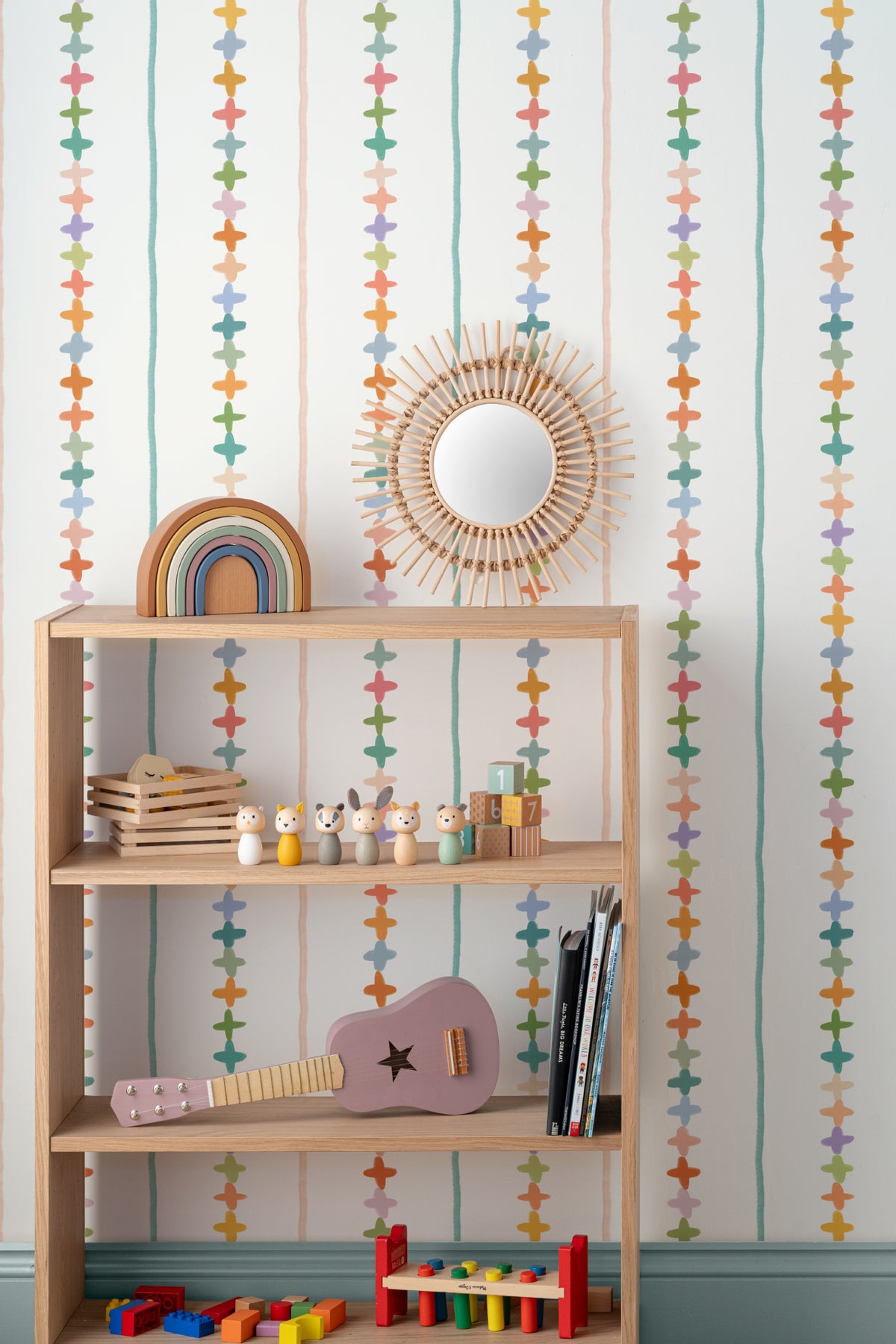 The Ribbon Maypole wallpaper in sage and sherbet on a nursery wall