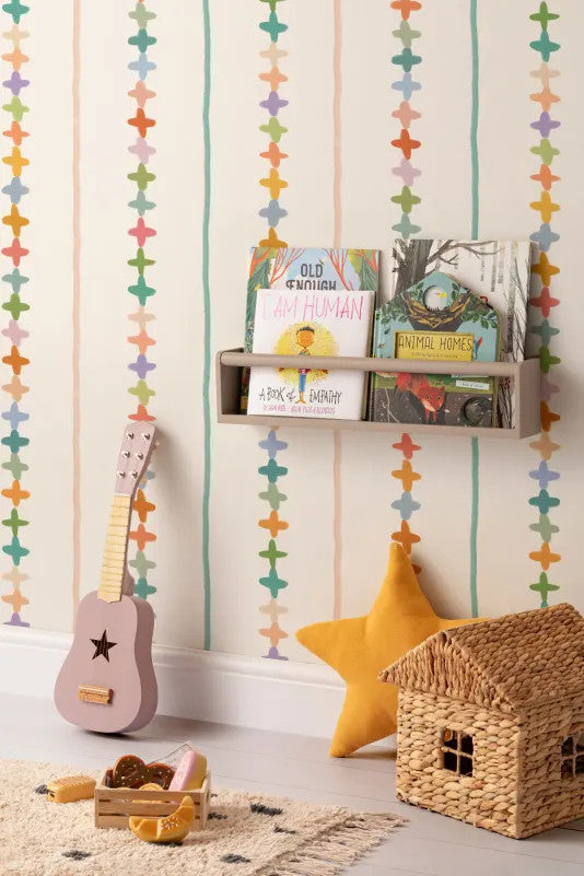 The Ribbon Maypole wallpaper in sage and sherbet behind a kids' play corner