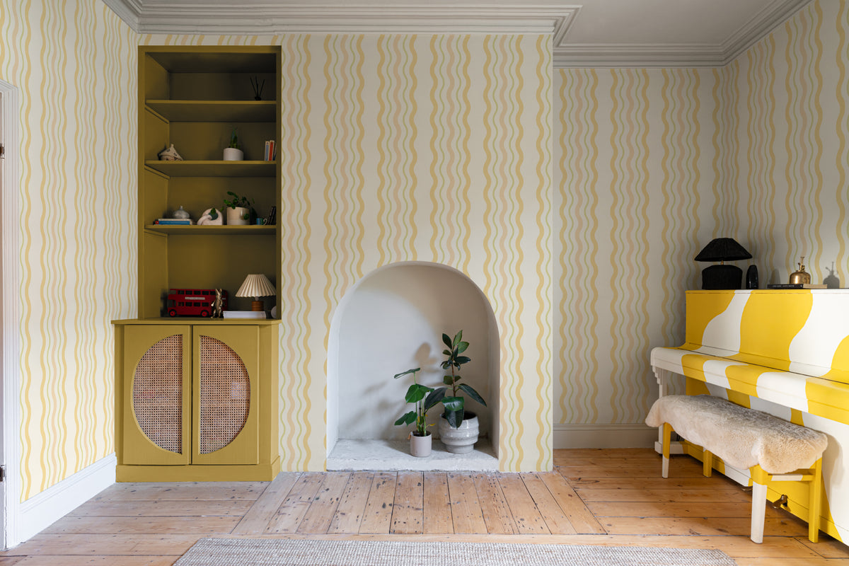 The Ripple Trim wallpaper in buttercup yellow in a living room
