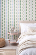 The Ripple Trim wallpaper in sage and sky behind the bed in a bedroom