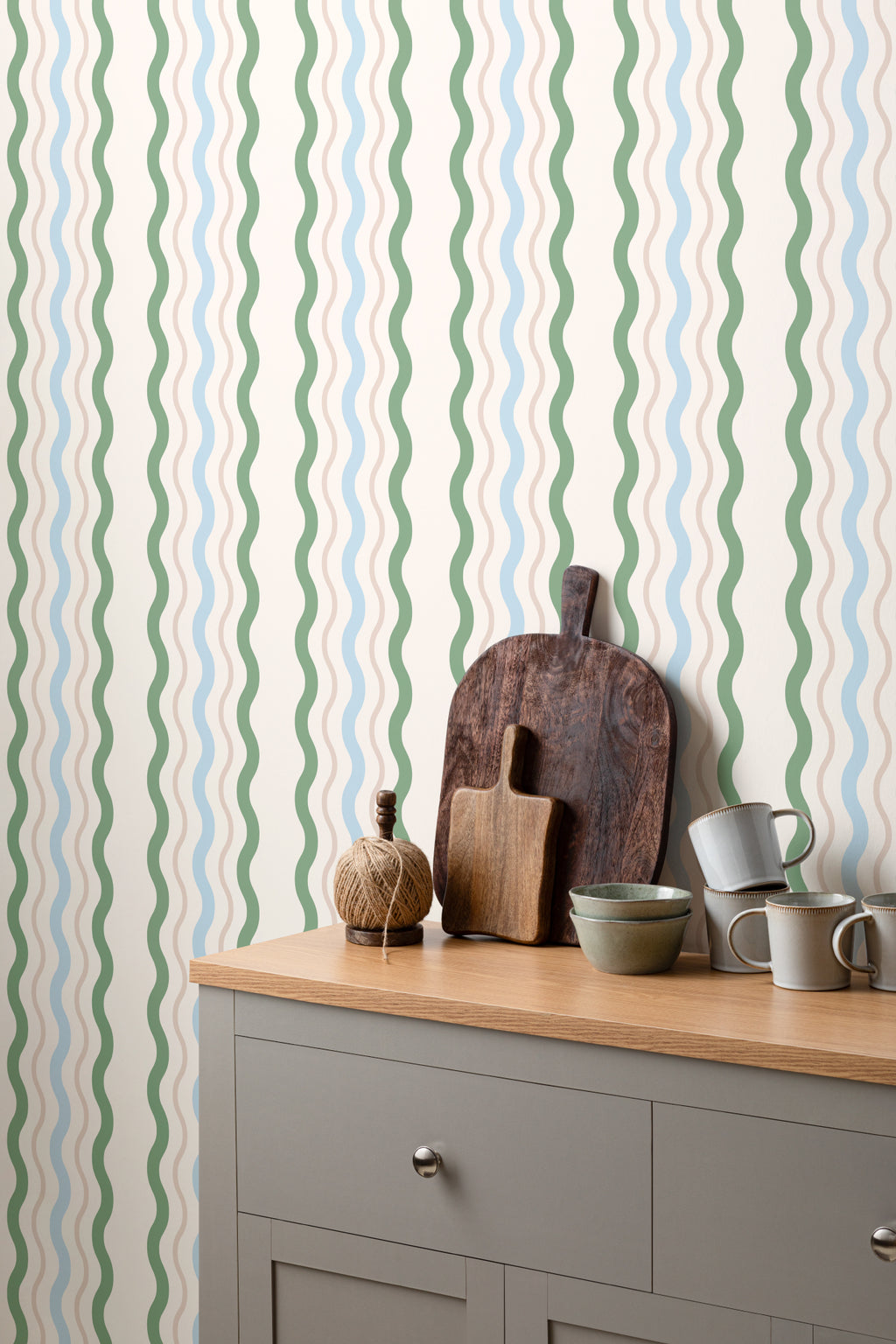 The Ripple Trim wallpaper in sage and sky behind a styled console