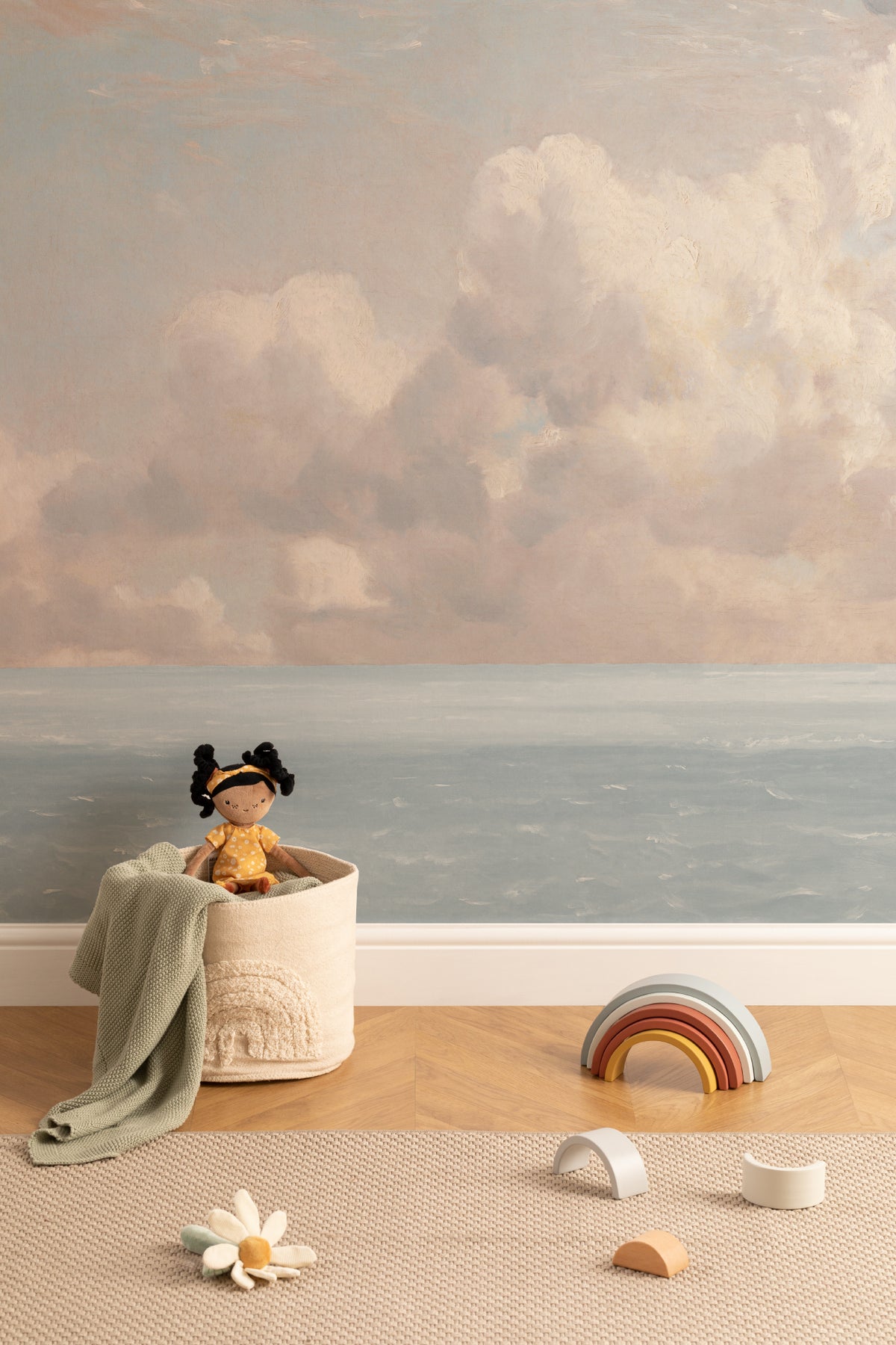 The Seaward Sky mural in peach and sea blue behind a kids' play corner