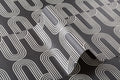 Angled detail of The Serpentine Line wallpaper in ink black and white