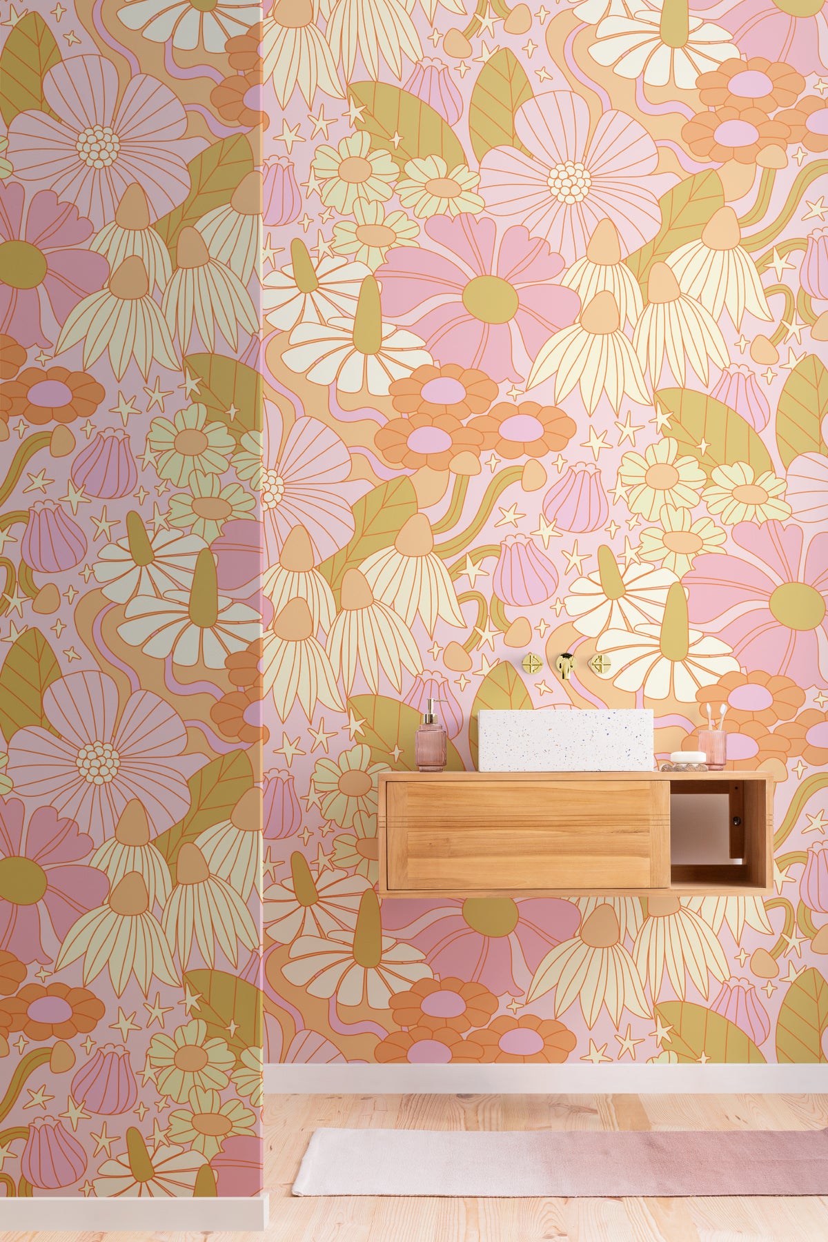 The Seventies Bloom mural in pastel pink behind a desk in a home office