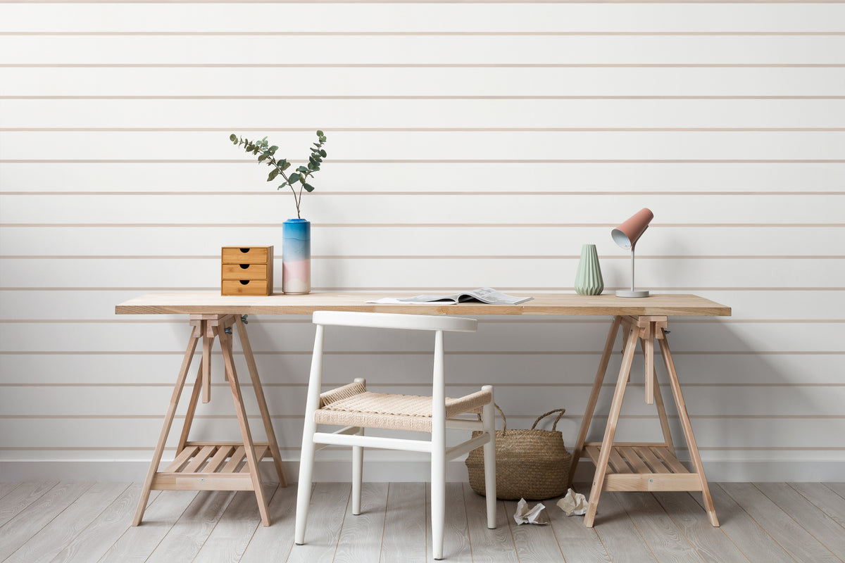 The Shoreline Stripe wallpaper in soft sand behind a desk in a home office