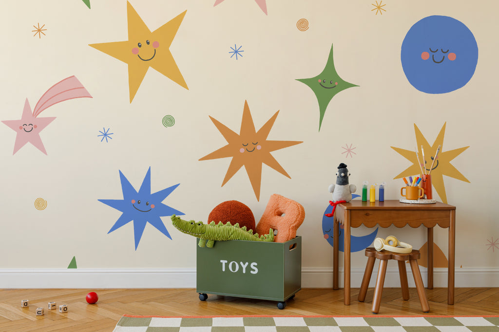 The Smiling Cosmos mural in sunshine and cobalt behind a kids' play corner